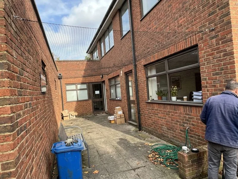Bird netting installed across a commercial building courtyard